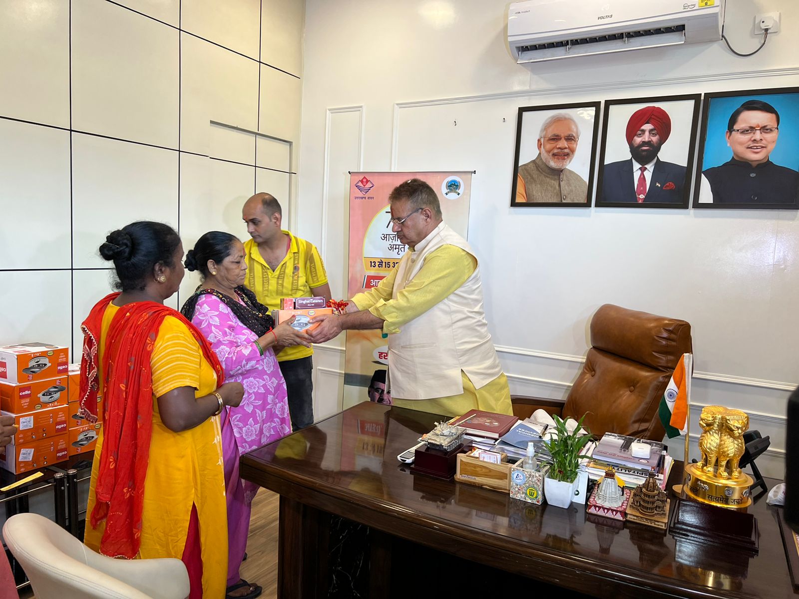 देहरादून : कैबिनेट मंत्री गणेश जोशी को रक्षासूत्र बांधती नगर निगम की महिला पर्यावरण मित्र।
