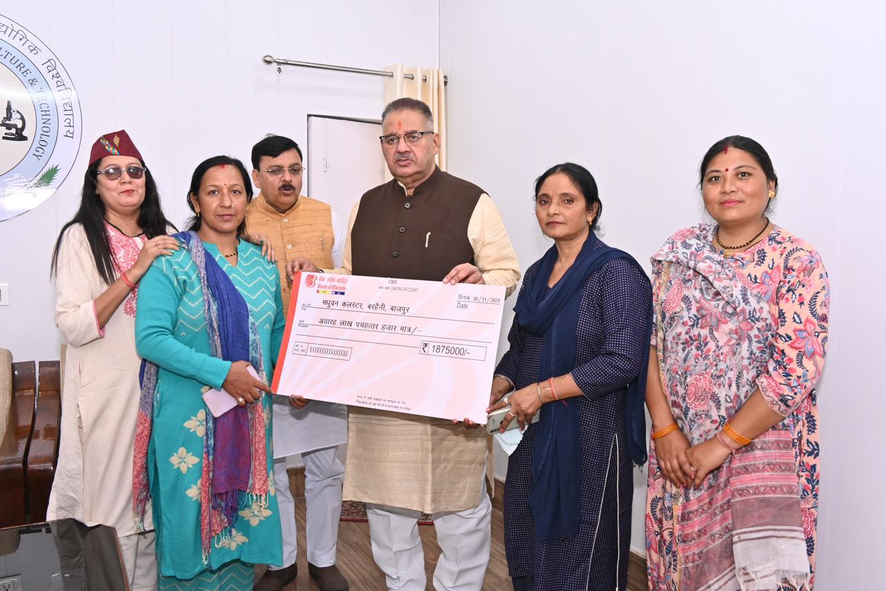 Rural Development Minister Ganesh Joshi distributing CIF and CLF checks to women of self-help groups through various schemes in Pantnagar.